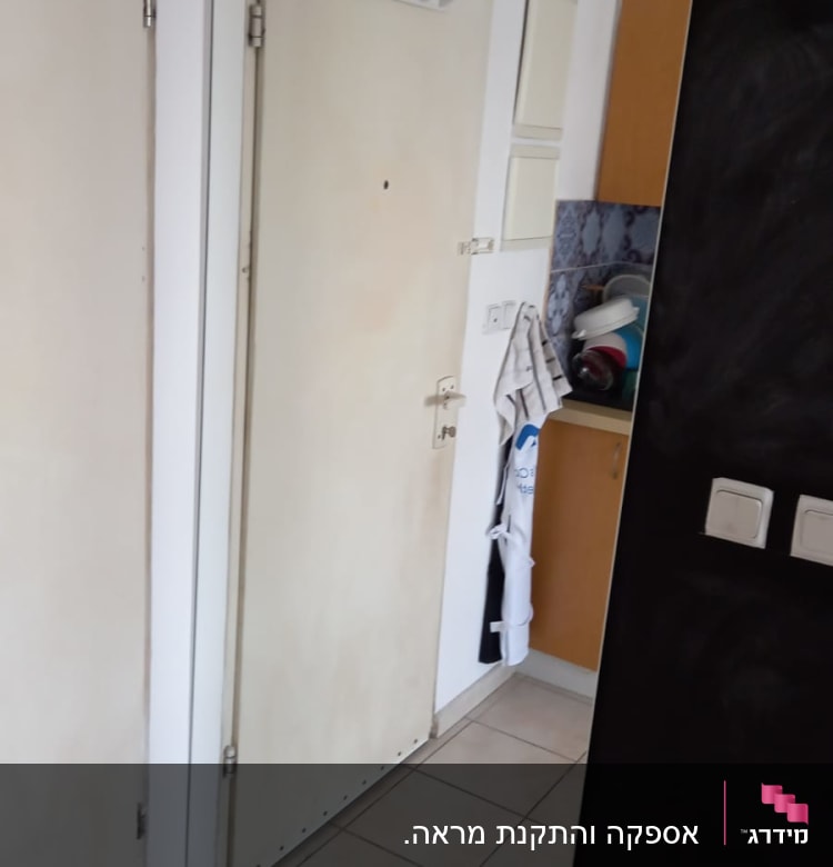 מראה גדולה על קיר ליד דלת כניסה